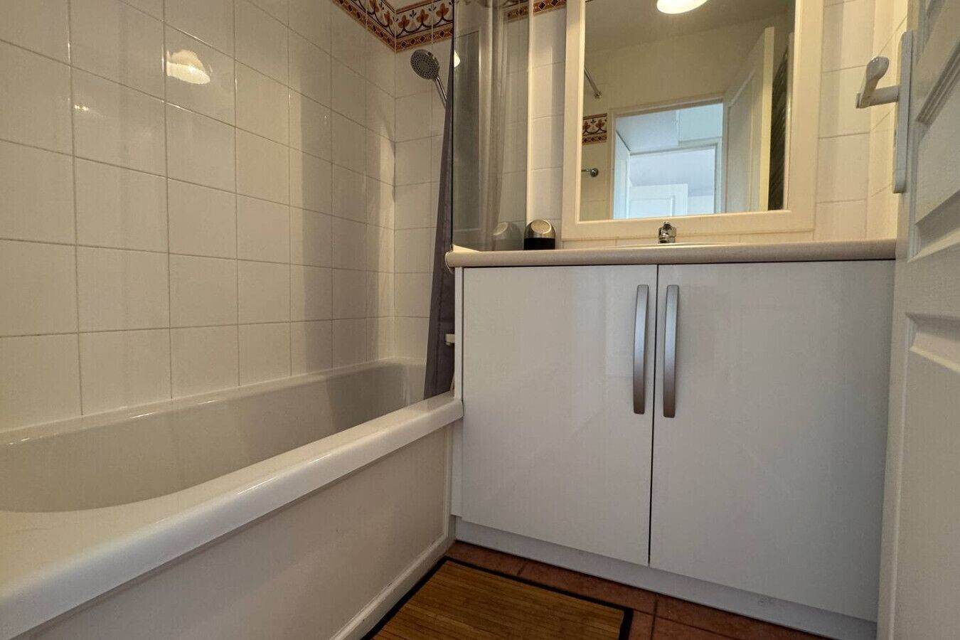 Un bagno con vasca, doccia, specchio e armadietto.