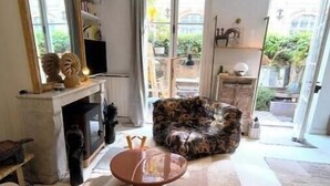 Un salon comprenant un canapé, une table basse, une cheminée et un grand miroir.