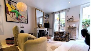 Un salon avec un canapé, un fauteuil et un grand miroir.