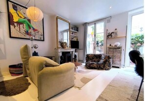 Ein Wohnzimmer mit einer Couch, einem Sessel und einem großen Spiegel.
