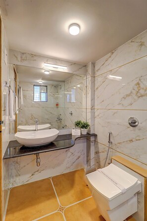 A modern bathroom with a large mirror, a white sink, a shower, and a toilet. - Esperanza Villas by SVAR Stays (Wai)