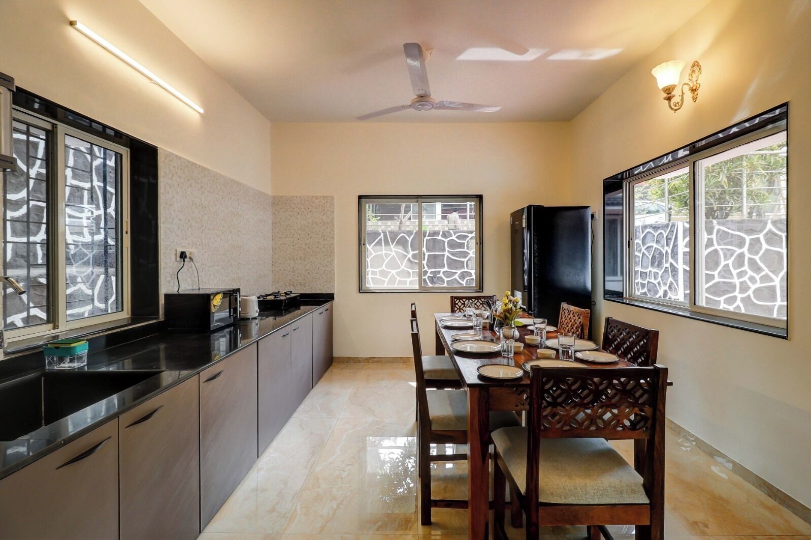 Una cocina moderna con comedor, ventanas amplias y un ventilador de techo.