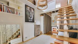 Een modern interieur met een trap, boekenkasten, een lijstwerk en een geweven lamp.