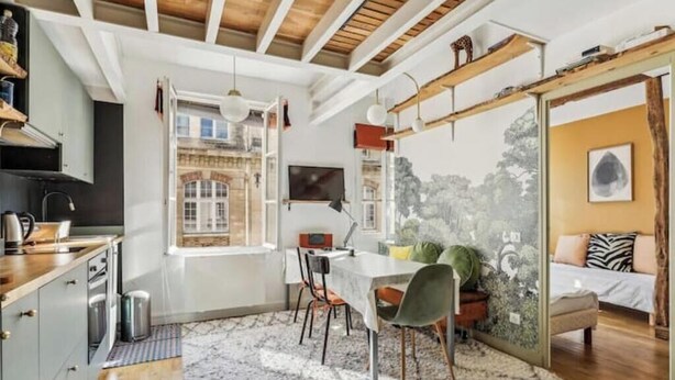 Een moderne keuken met een eethoek, een groot raam en een bed met uitzicht.