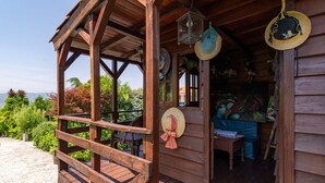 Una cabana de fusta amb un porxo, una taula i un barret penjant.