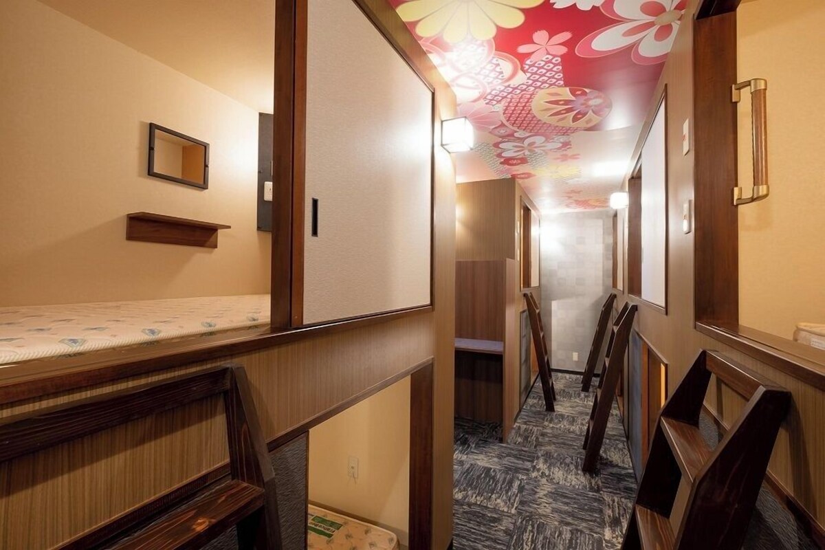 A hotel hallway with wooden walls, a patterned carpet, and a ceiling with floral designs.
