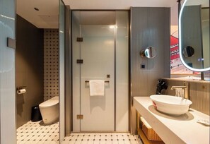 A modern bathroom with a glass shower enclosure, a white sink with a vessel basin, and a large mirror above the sink. - Y.TUO HOTEL - Xi'an Bell Tower (Xi'an)