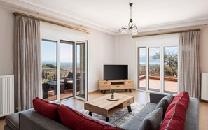 Un salon moderne avec un canapé, une table basse, un téléviseur et un balcon offrant une vue agréable.