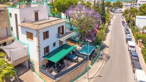 Un immeuble de deux étages doté d’une terrasse sur le toit, d’une piscine et offrant une vue sur la rue.