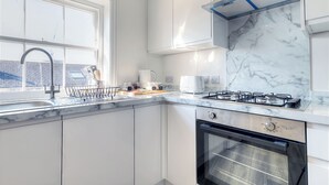 Una cocina moderna con horno empotrado, cocina a gas y ventana con vistas a la ciudad.
