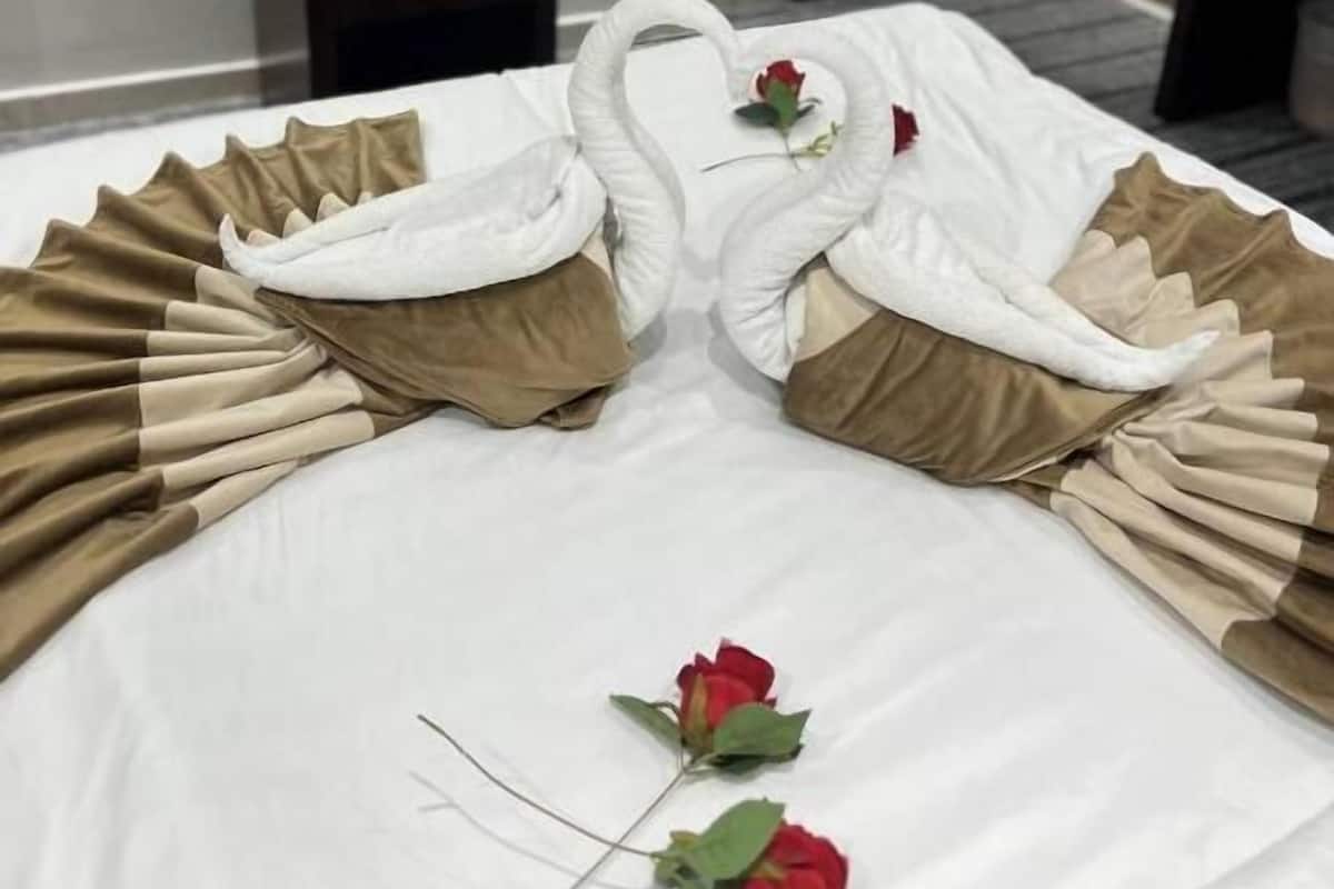 Una cama con un diseño decorativo de cisne y rosas.