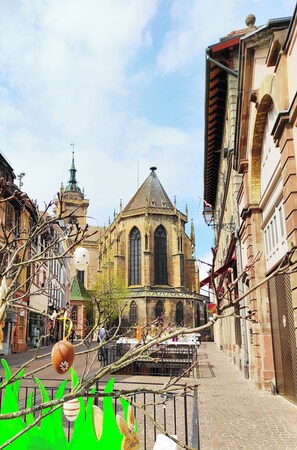 A historic church with a prominent tower and arched windows, surrounded by narrow streets and traditional buildings.