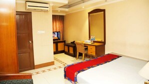 A hotel room with a bed, a desk with a chair, a television, and an air conditioning unit. - 1-bedroom hotel in enchanting Dhaka with fitness room and AC (Dhaka)