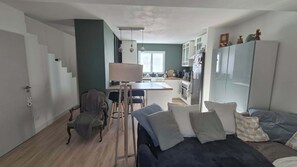Ein gemütlicher Wohnbereich mit einer Couch, einem Esstisch und einer Küchenzeile.
