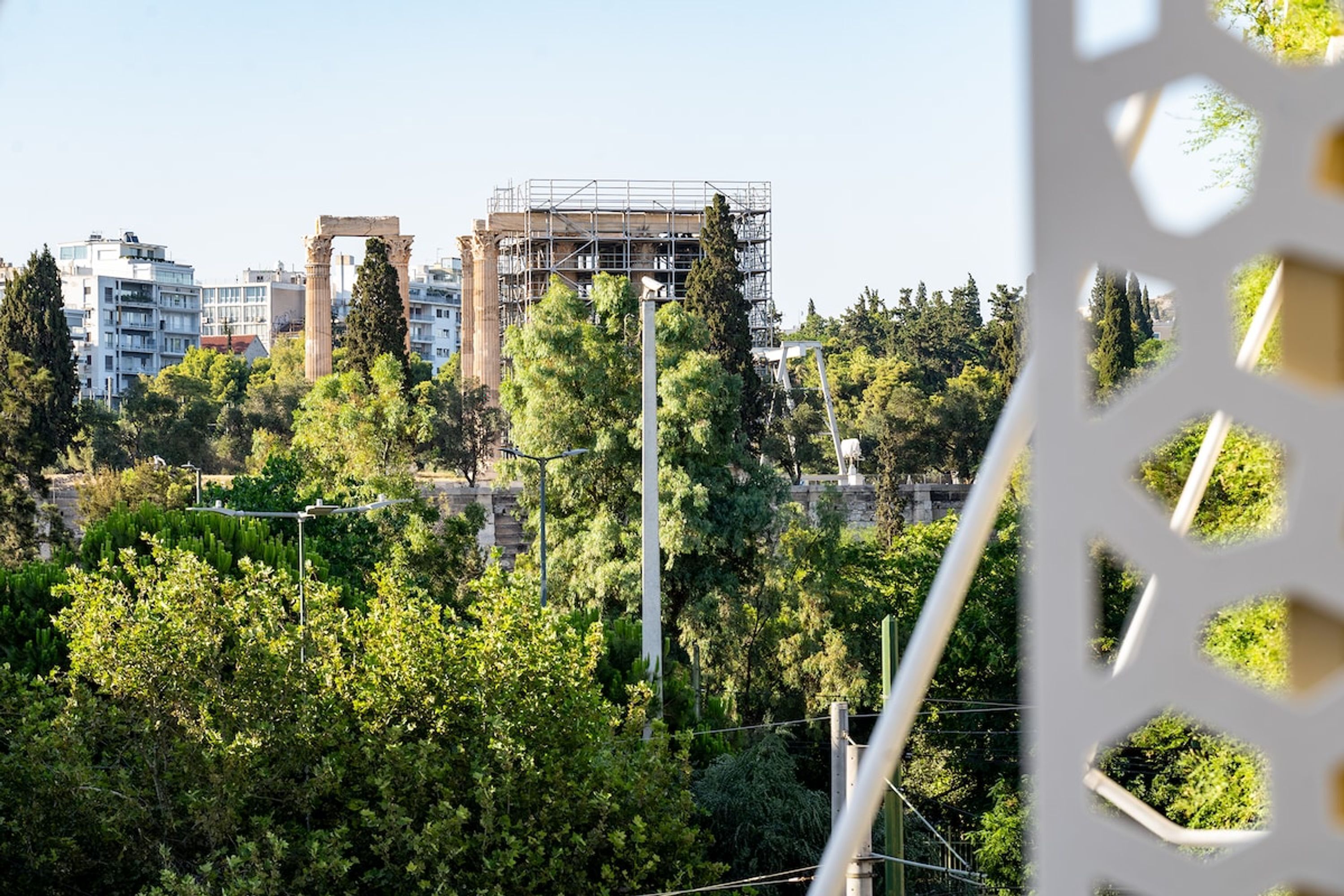 A view of ancient ruins with modern buildings in the background.