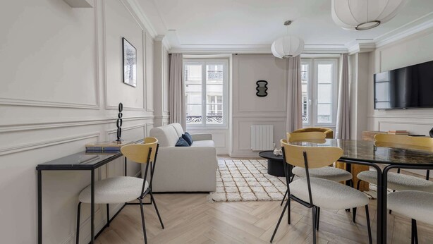 A modern living room with a sofa, dining table, chairs, and a TV. - Charming apartment 2BDR/6PAX in the heart of Paris (Paris)
