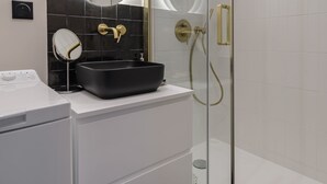 A modern bathroom with a glass-enclosed shower, a black vessel sink, and a white vanity. - Charming apartment 2BDR/6PAX in the heart of Paris (Paris)
