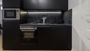 Uma cozinha moderna com micro-ondas, forno e lava-louças embutidos.