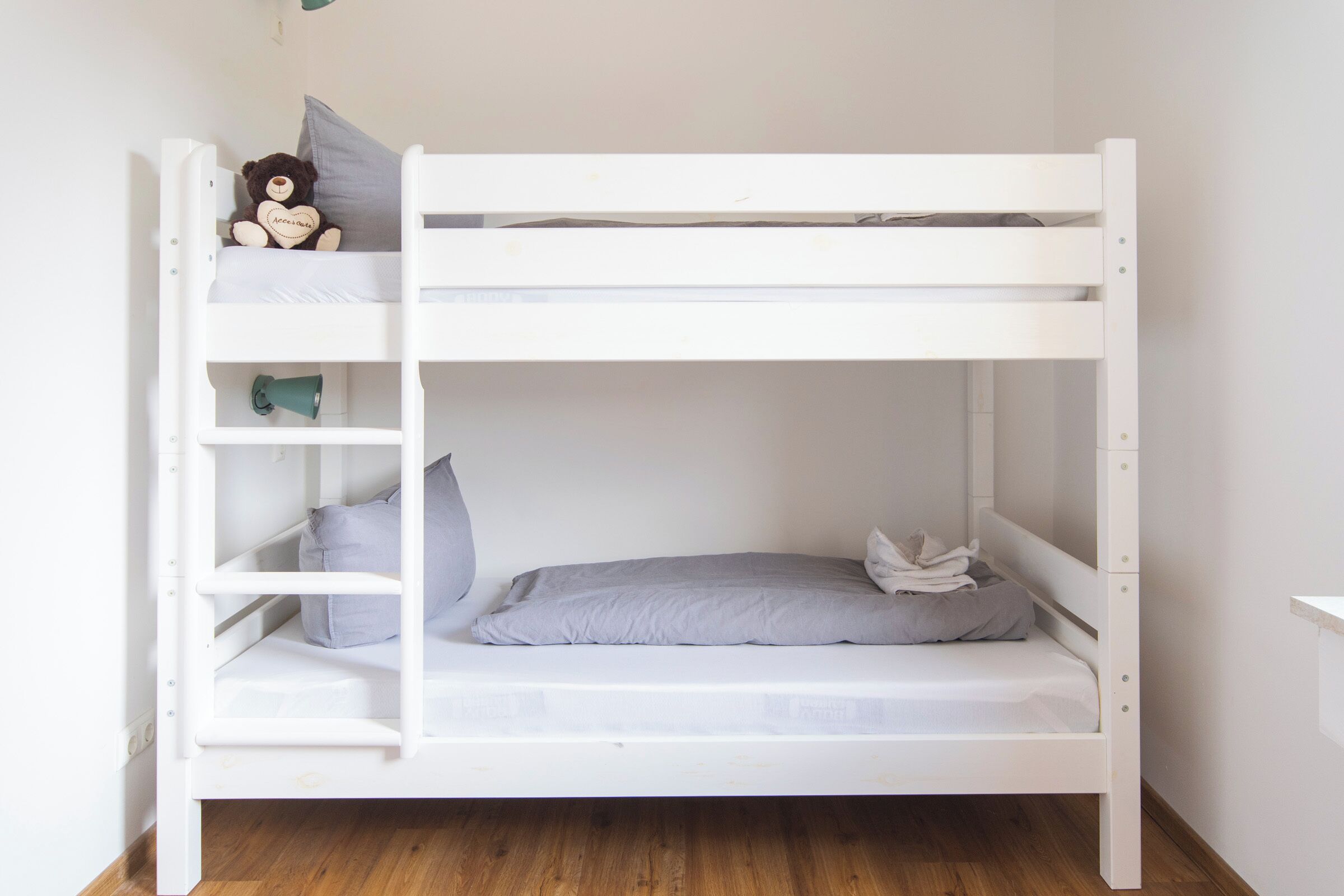 A bunk bed with a shelf on the left and a mattress on the right.
