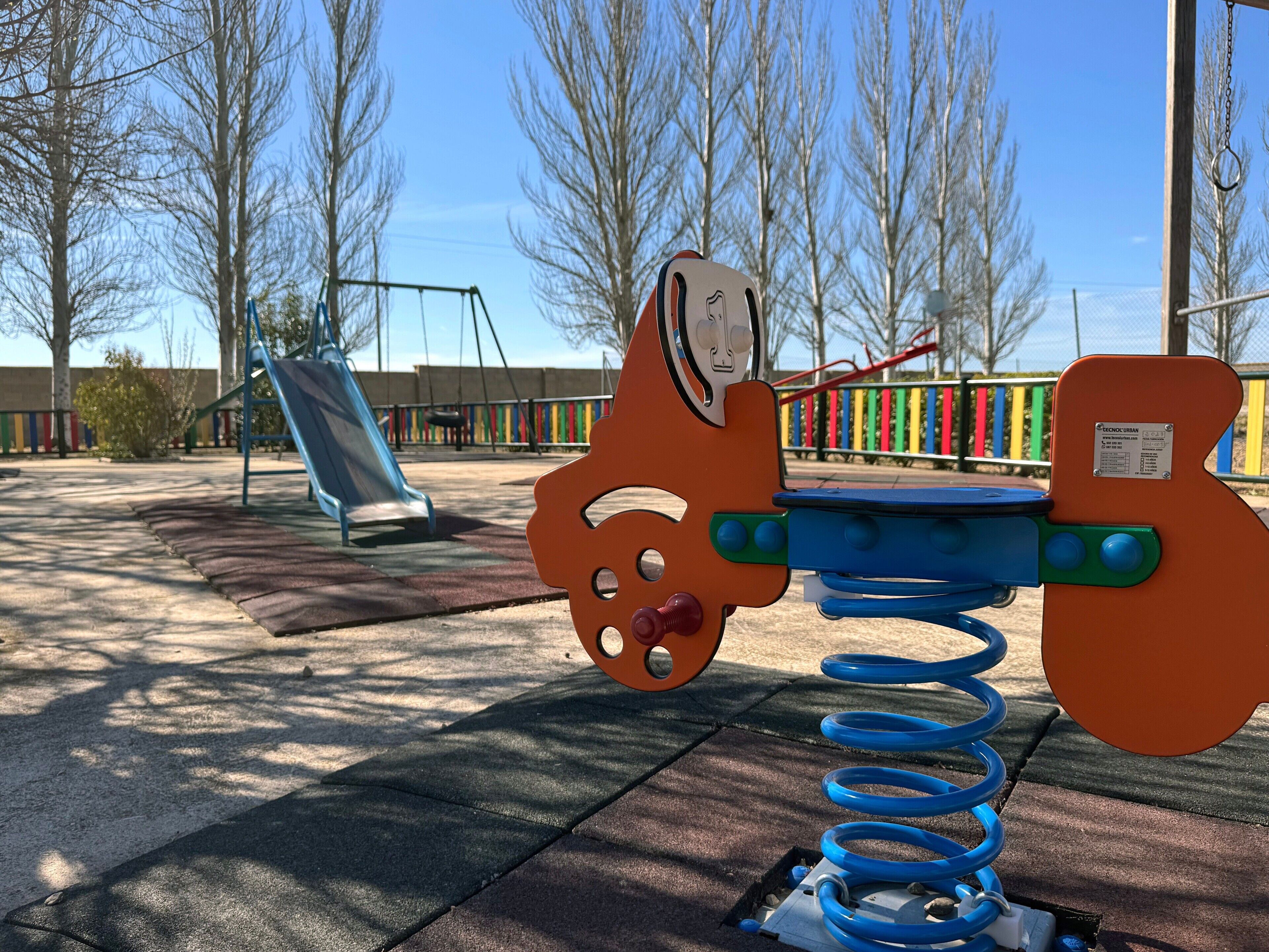 A playground with a seesaw, a slide, and a swing set.
