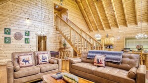 Un intérieur en bois comprenant deux canap és, un escalier en bois et un coin repas.