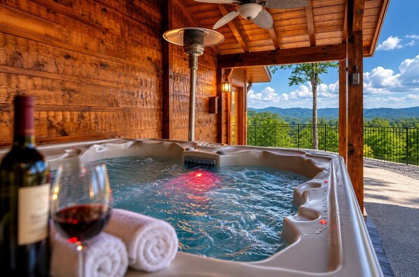 A wooden cabin with a hot tub, a bottle of wine, and a glass on the floor. - Smoky Sunset Retreat, Hot Tub, Mountain Views, Free Tickets! (Sevierville)