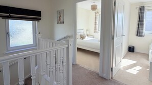 A bedroom with a bed, a window, a ceiling fan, and a door leading to another room. - Inverness Retreat, visit the capital of the Highlands and relax! (Inverness)