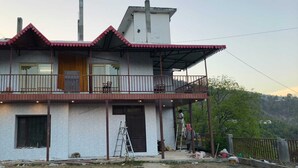 Ένα διώροφο σπίτι με ένα μπαλκόνι, μια πόρτα και ένα παράθυρο.