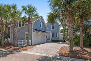 A residential property with a garage, two-story structure, and a paved driveway. - WaterSound Retreat | Private Pool | Near 30A Beach (Watersound)