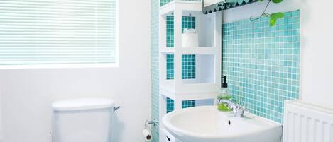 A bathroom with a toilet, sink, and tiled floor.