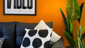 A framed poster with the word 'VIDEOS' and a lamp on a wall. - Comfy 3-bed City Home Parking Near Deansgate (Manchester)