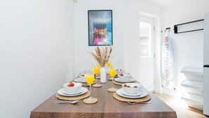 A dining table set with plates, glasses, and a vase with dried plants. - Comfy 3-bed City Home Parking Near Deansgate (Manchester)