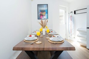 A dining table set with plates, glasses, and a vase with dried plants. - Comfy 3-bed City Home Parking Near Deansgate (Manchester)