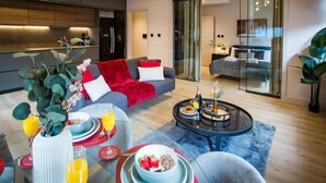 A modern living room with a sofa, coffee table, and breakfast setup. - Stylish Manchester City Escape Walk to Chinatown (Manchester)