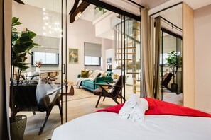 A modern hotel room with a bed, a desk, a chair, a sofa, and a staircase. - Spacious Central Location For Families Walk to All (Manchester)
