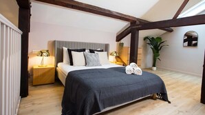 A bedroom with a bed, bedside tables, a skylight, a potted plant, and a mirror. - Spacious 3-bed Retreat Modern Super Central (Manchester)