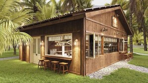 A wooden building with a bar area, bar stools, and a paved walkway. - Nirvana Beach Villages (Mui Ne)
