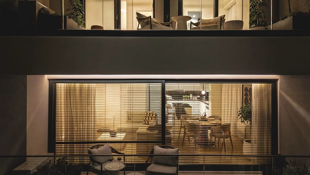 Un intérieur moderne comprenant un coin repas, des sièges et une vue dégagée grâce à de grandes fenêtres.
