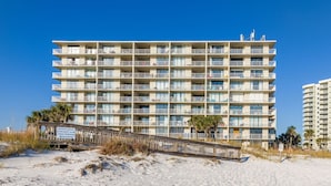 Een hotel met meerdere verdiepingen en balkons, nabij een strand.