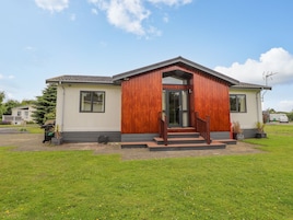 A single-story house with a front porch, a visible garage door, and a well-maintained lawn.