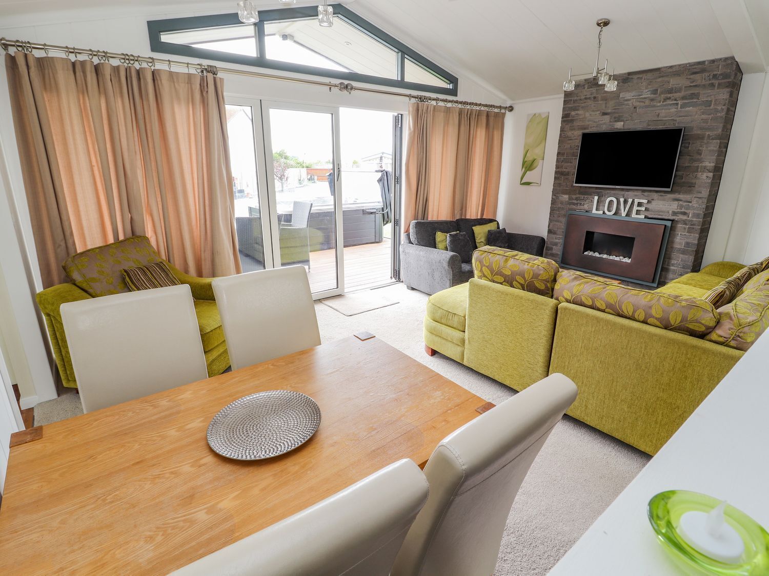 A modern living room with a sofa, a dining table, and a fireplace.
