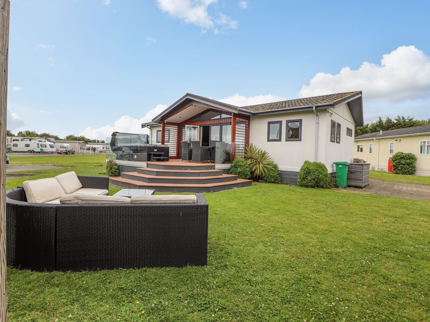 Una casa moderna con un patio, mobiliario exterior y vistas del entorno.