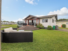 Una casa moderna con un patio, mobiliario exterior y vistas del entorno.