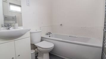 Un baño con lavamanos, inodoro y bañera.