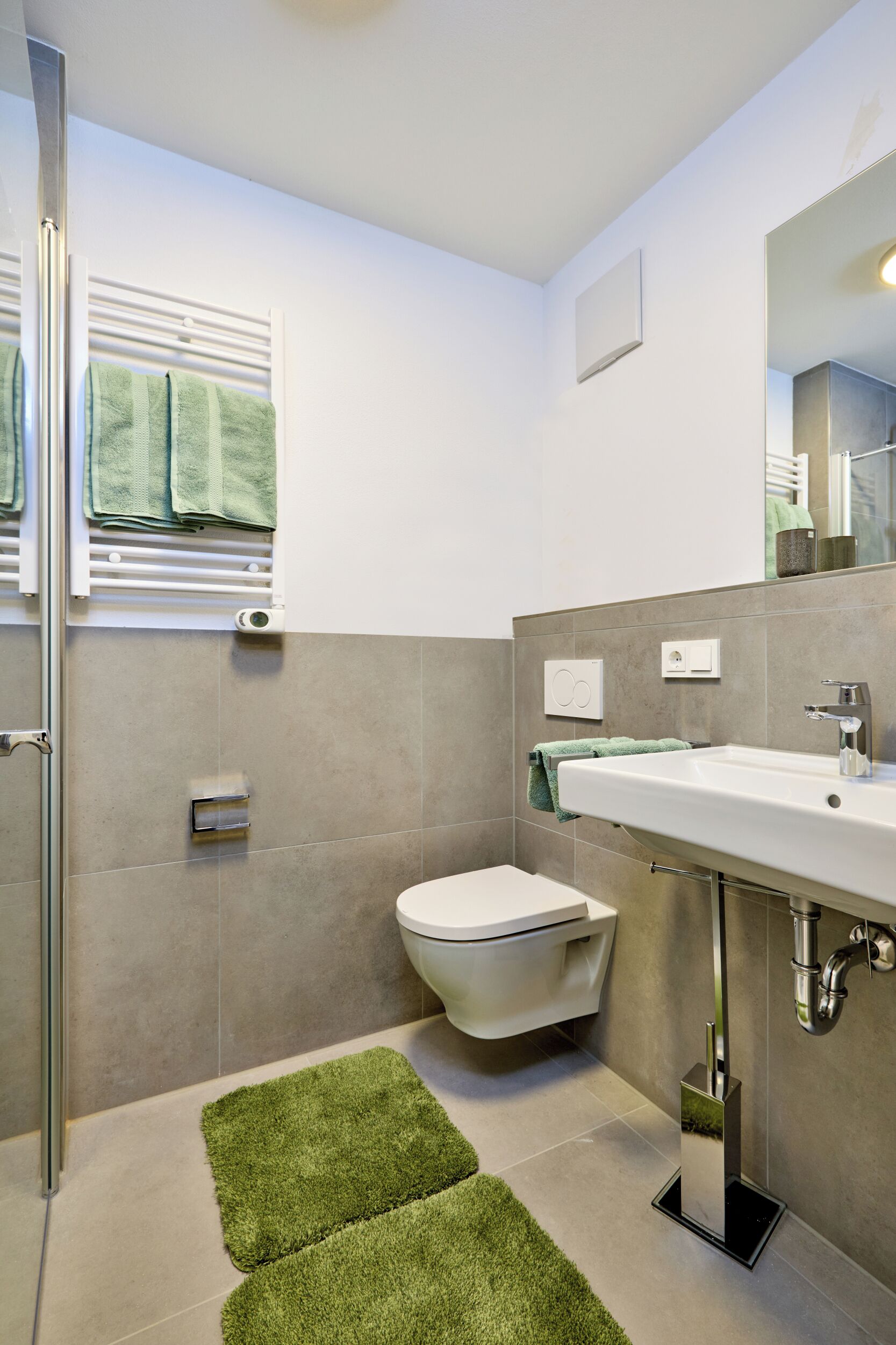Une salle de bain avec des toilettes, un lavabo et une douche.