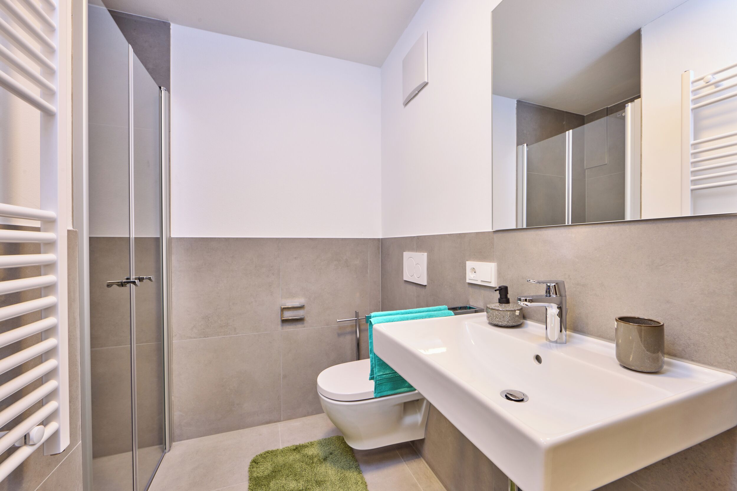 Une salle de bain moderne équipée d’une douche, de toilettes et d’un lavabo.