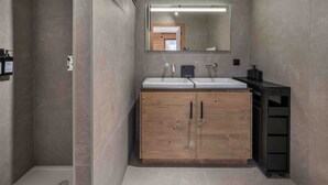 A modern bathroom with a wooden vanity, two sinks, a large mirror, and a shower area. - Renovated and bright apartment - 6 guests (Megève)