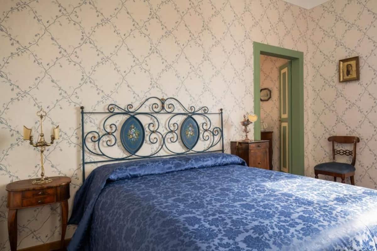 A bedroom with a bed, a nightstand, a dresser, and a chair.
