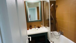 Ein Badezimmer mit Waschbecken, Spiegel und Dusche.