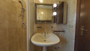 A bathroom with a sink, mirror, and shower. - Spacious Apartment With two Balconies (Lignano Sabbiadoro)